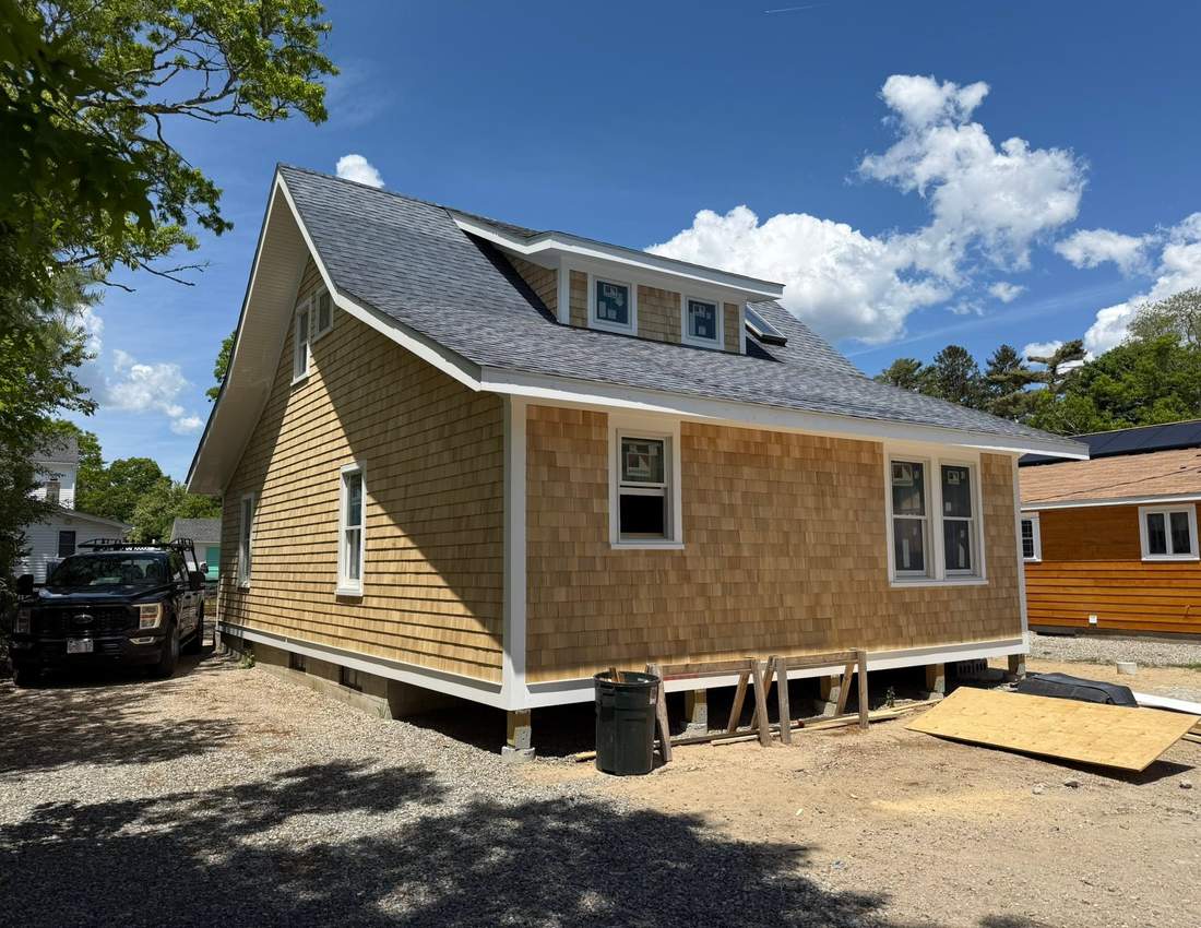 Whole-home cedar shingle siding with new white trim and windows on a South Shore home