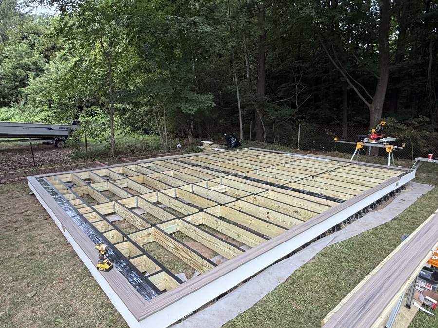 Pressure-treated framing for a ground-level composite deck in progress on the South Shore