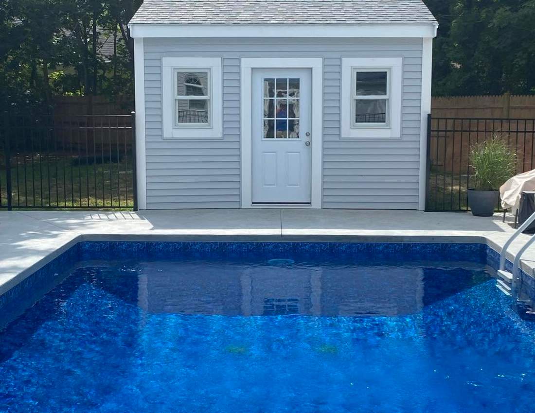 Custom poolside shed with vinyl siding and a shingle roof built on the South Shore