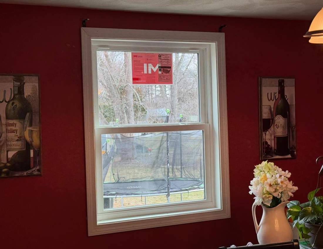 New white double-hung replacement window with custom interior trim on a South Shore home