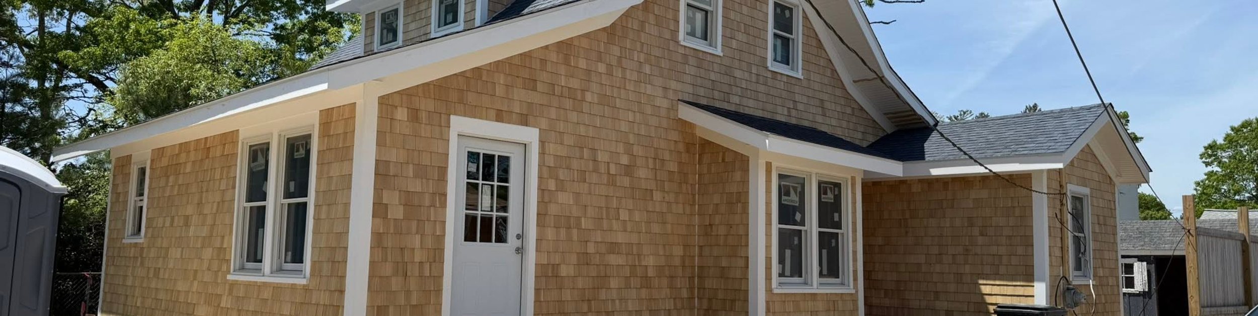 Completed cedar shingle exterior renovation with a new roof, trim, and windows on a South Shore home by CB Builders Corp.